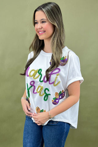 Woman wearing a white t-shirt with colorful text and graphics on a green background