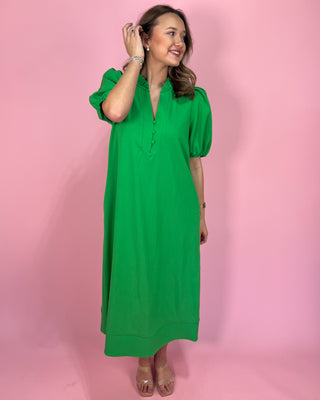 Woman wearing a green dress against a pink background