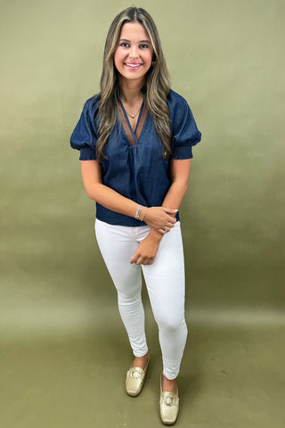 Cream and navy puff sleeve blouse with geometric print styled with light wash wide leg jeans and white sneakers.