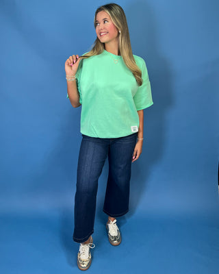 Mint green LULU MAC short sleeve top with a relaxed fit, styled with dark wash wide leg jeans.