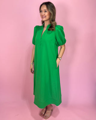 Woman wearing a green dress against a pink background