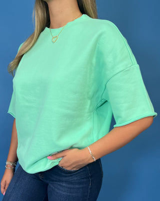 Mint green LULU MAC short sleeve top with a relaxed fit, styled with dark wash wide leg jeans.