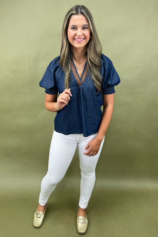 Cream and navy puff sleeve blouse with geometric print styled with light wash wide leg jeans and white sneakers.