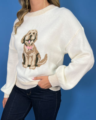 Ivory knit sweater with a cute dog graphic, pink bow detail, crew neckline, and relaxed fit.