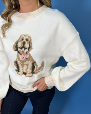 Ivory knit sweater with a cute dog graphic, pink bow detail, crew neckline, and relaxed fit.