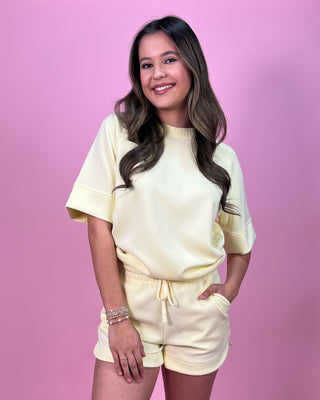 Woman wearing a yellow outfit against a pink background