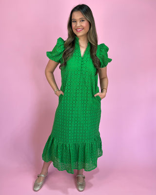 Woman wearing a green dress against a pink background