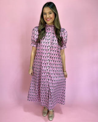 Woman wearing a pink patterned dress against a pink background