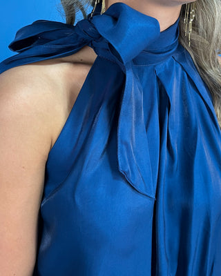 Navy satin sleeveless top with a statement tie neckline, soft pleating, and a relaxed blouson fit.