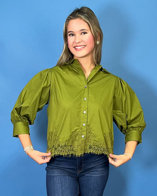 Olive green button-up blouse with puff sleeves and lace trim hem, styled with dark wash cropped jeans.