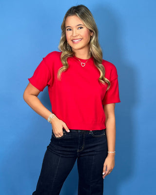 Bright red short sleeve knit sweater top with a crew neckline, ribbed trim, and relaxed fit.
