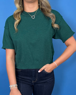 Hunter green short sleeve knit sweater top with a crew neckline, ribbed trim, and relaxed fit.