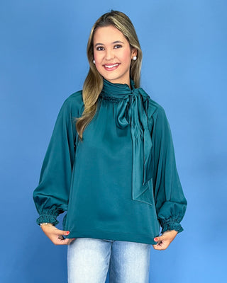 Emerald green satin blouse with a tie neck, long balloon sleeves, and gathered cuffs, shown on model.