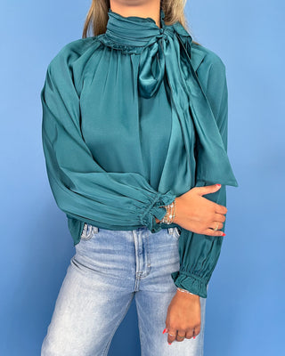 Emerald green satin blouse with a tie neck, long balloon sleeves, and gathered cuffs, shown on model.