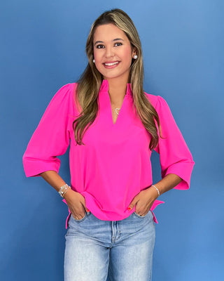 Hot pink blouse with a ruffle split neckline, three-quarter balloon sleeves, and relaxed fit, shown on model.