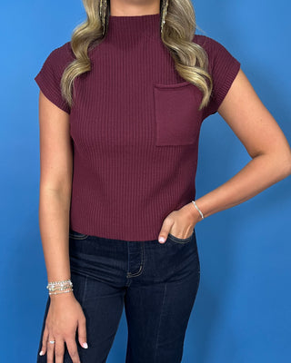 Burgundy ribbed mock neck cap sleeve top with a front chest pocket and relaxed fit.