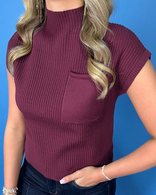 Burgundy ribbed mock neck cap sleeve top with a front chest pocket and relaxed fit.