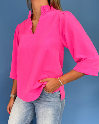 Hot pink blouse with a ruffle split neckline, three-quarter balloon sleeves, and relaxed fit, shown on model.