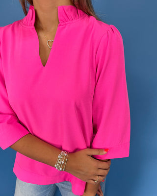 Hot pink blouse with a ruffle split neckline, three-quarter balloon sleeves, and relaxed fit, shown on model.