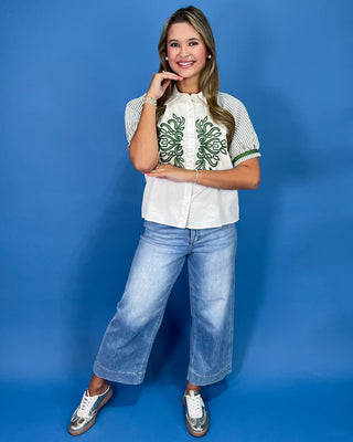 White button-up blouse with green embroidery, striped puff sleeves, and a collared neckline, shown on model.