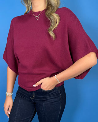 Burgundy short sleeve dolman knit sweater top with a mock neckline and relaxed fit.