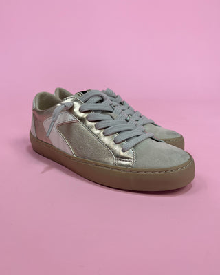 Light gray sneakers with a metallic accent on a pink background