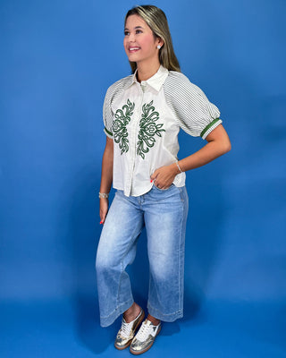 White button-up blouse with green embroidery, striped puff sleeves, and a collared neckline, shown on model.