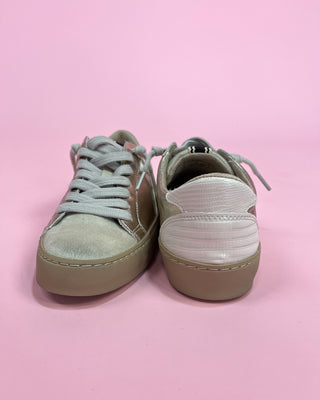 Pair of light gray sneakers on a pink background