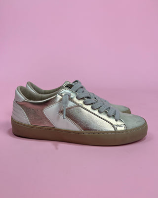 Silver and pink sneakers on a pink background