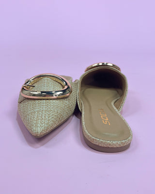 Pair of light green espadrilles with gold accents on a pink background