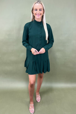 Woman wearing a green dress against a plain background