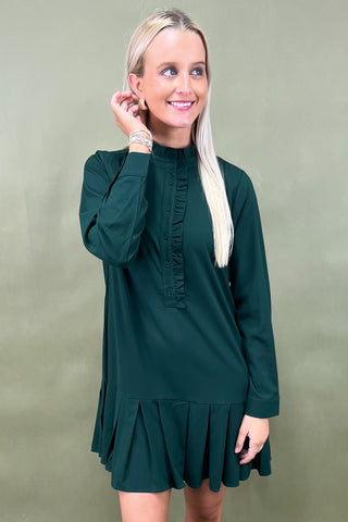 Woman wearing a green dress against a plain background