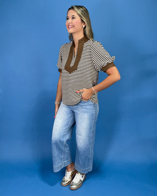 Brown and cream striped top with contrast collar, split neckline, and puff sleeves, shown on model.