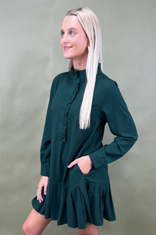 Woman wearing a green dress against a plain background