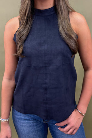 Person wearing a navy sleeveless top against a plain background