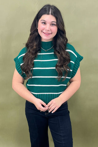 Woman wearing a green and white striped sweater against a green background
