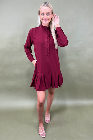 Woman wearing a burgundy dress with a plain background