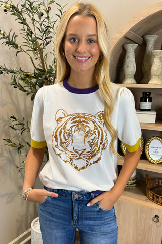 Woman wearing a white t-shirt with a tiger design in a home setting
