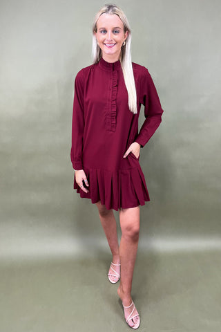Woman wearing a burgundy dress against a plain background