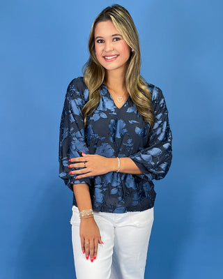 Navy blue floral textured blouse with a V-neck and three-quarter balloon sleeves, shown on model.