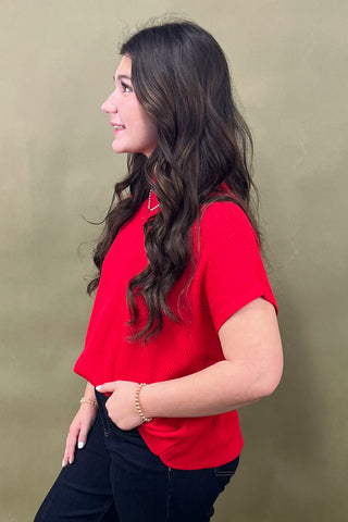 Woman wearing a red shirt against a beige background