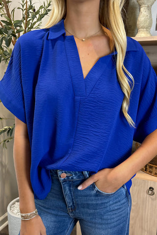 Person wearing a blue top and jeans indoors