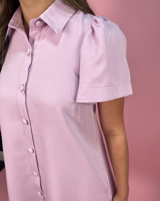 Pink short-sleeve shirt worn by a person on a pink background