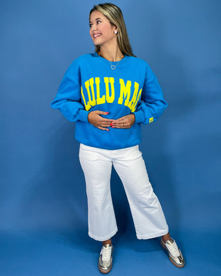 Woman wearing a sweatshirt with text against a blue background