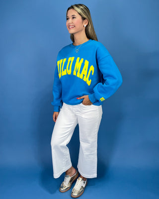 Woman wearing a sweatshirt with text against a blue background