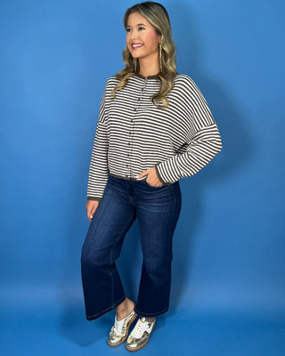 Chocolate brown and ivory striped knit cardigan with button-front detail, drop shoulders, long sleeves, and a relaxed fit.