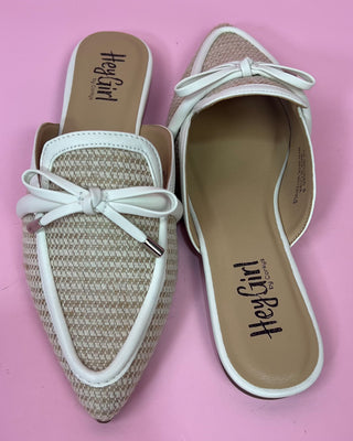 Pair of flat shoes with white bows on a pink background