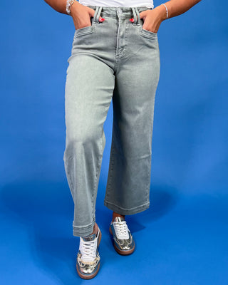 Light sage green wide leg jeans with a high-rise waist and relaxed fit, shown on model.