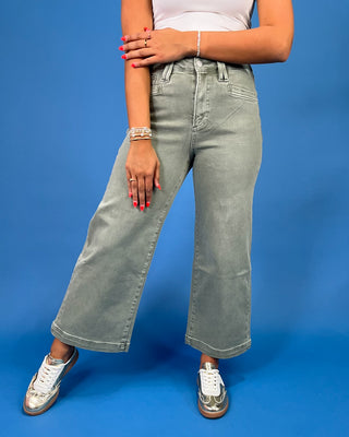 Light sage green wide leg jeans with a high-rise waist and relaxed fit, shown on model.