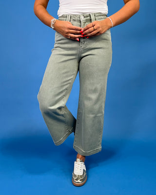 Light sage green wide leg jeans with a high-rise waist and relaxed fit, shown on model.